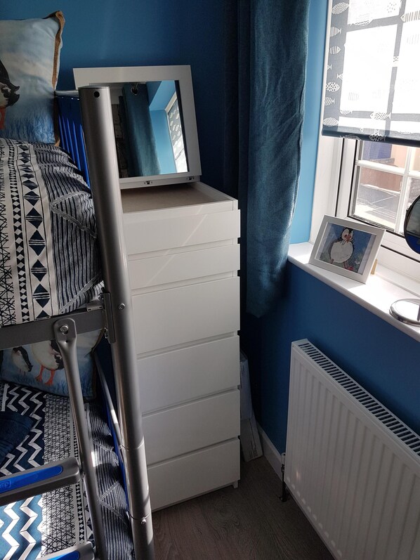 A room with a bunk bed, a desk with a computer monitor, a framed picture on the wall, and a window with curtains. - Puffin Cottage - Perfect for couples or a family holiday in Cornwall (Portreath)
