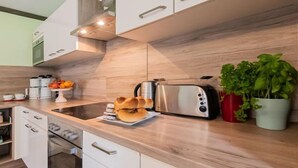 Una cocina moderna con armarios de madera, un tostador de acero inoxidable y una cafetera.