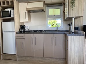 Fridge, microwave, coffee/tea maker, cookware/dishes/utensils