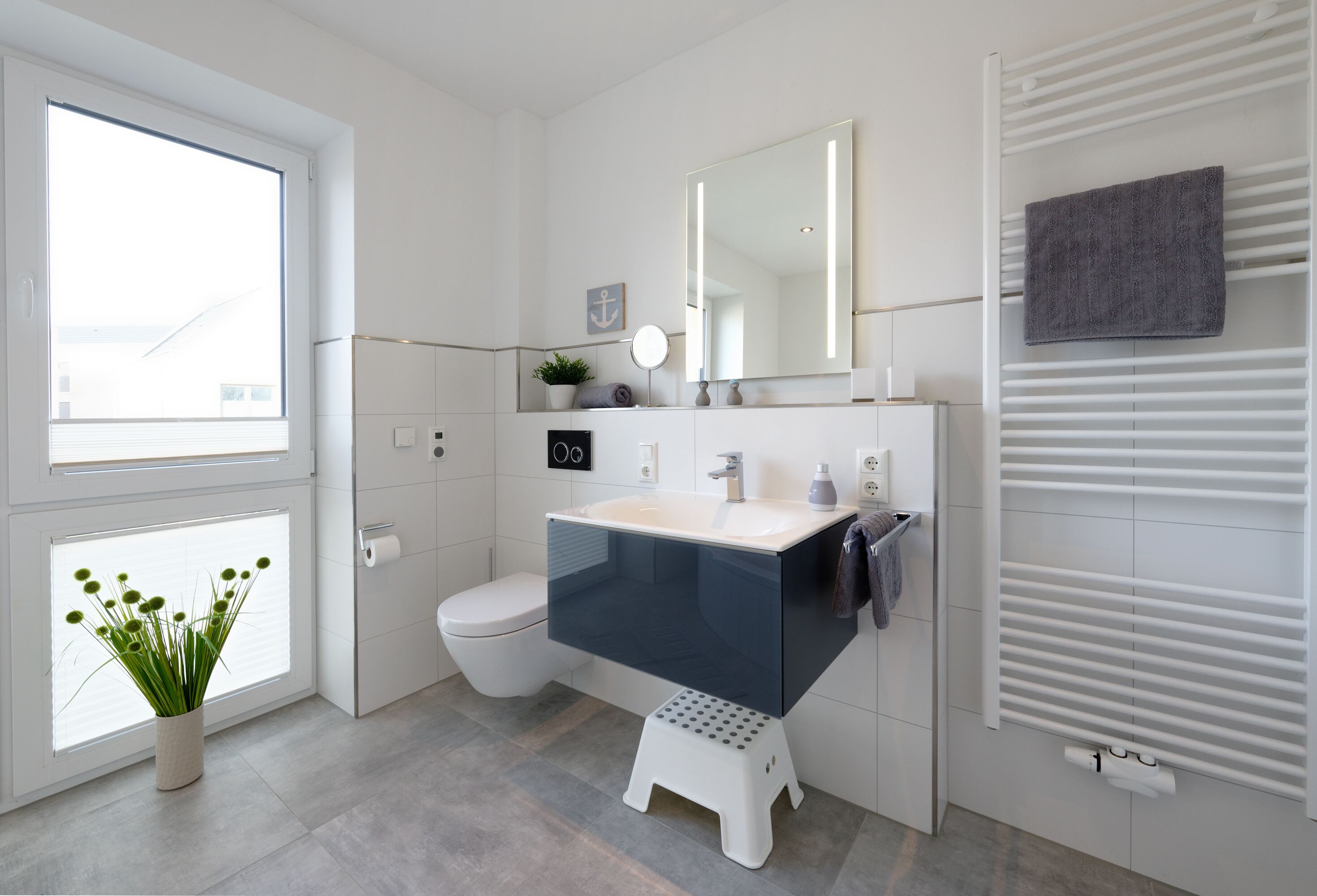 Ein modernes Badezimmer mit Toilette, Waschbecken und Spiegel.