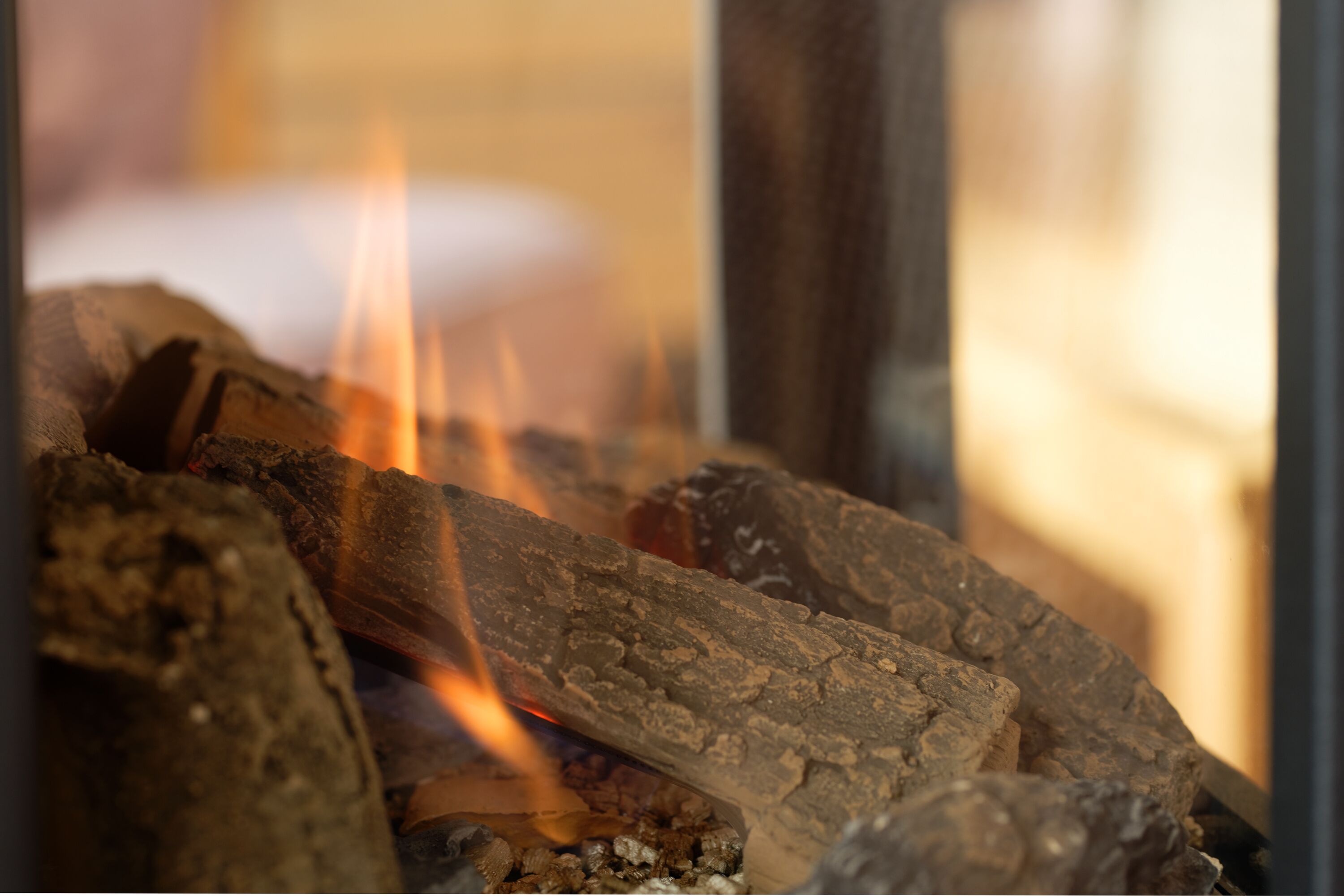 Un gros plan sur du bois en combustion, avec des flammes bien visibles.
