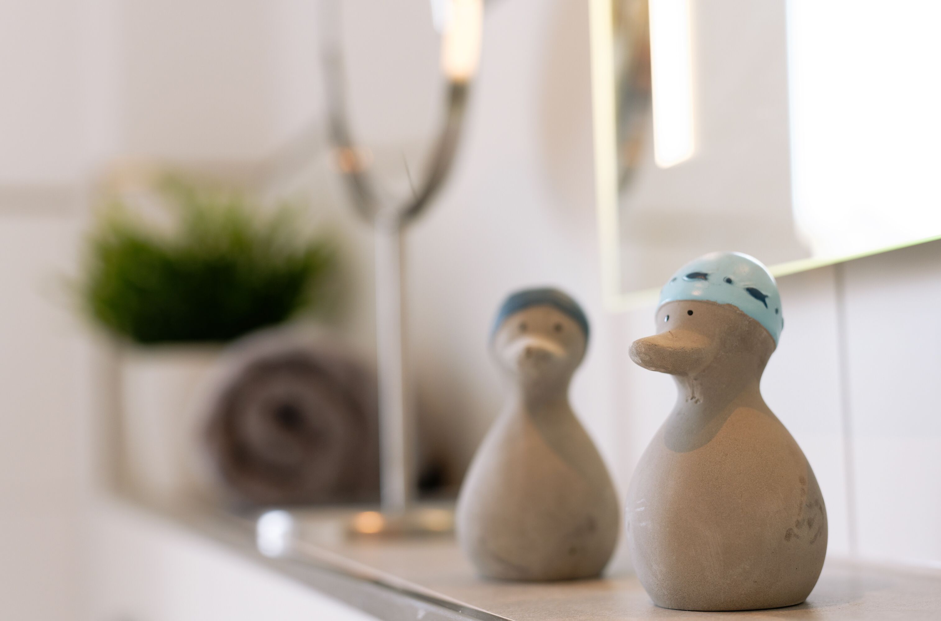 Two ceramic duck figurines on a shelf.