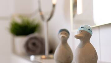 Two ceramic duck figurines on a shelf.