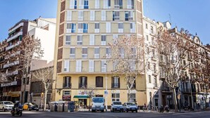 Un immeuble à plusieurs étages, doté d’une entrée centrale et de plusieurs fenêtres à chaque étage.