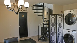 A modern interior with a black spiral staircase, a washing machine, and a chandelier. - Private house with 3 suites. Modern, Clean & Comfortable! (Portland)