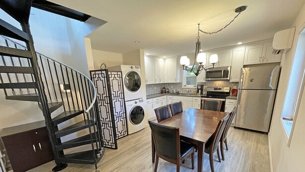 A modern kitchen with a dining area, built-in appliances, and a staircase. - Private house with 3 suites. Modern, Clean & Comfortable! (Portland)