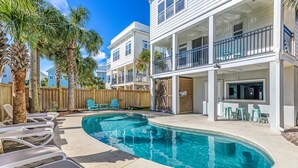 A swimming pool with lounge chairs, a wooden fence, and a two-story building with balconies. - 2 Rooftop decks, pool/elevator. Downtown IOP, 1 blk from beach. Pet friendly! (Isle of Palms)