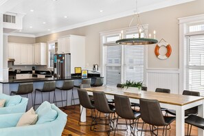 A modern kitchen with white cabinets, a stainless steel refrigerator, and a bar area. - 2 Rooftop Decks | Downtown IOP | Pool | Elevator | 1 Blk From Beach | Pets (Isle of Palms)