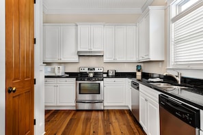 A kitchen with white cabinets, a stainless steel stove, a microwave, and a toaster. - 2 Rooftop Decks | Downtown IOP | Pool | Elevator | 1 Blk From Beach | Pets (Isle of Palms)