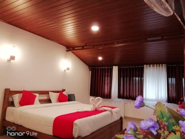 Relax in this serene space with a large bed and a view of the outside through the window.