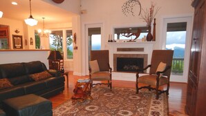 Una sala de estar con chimenea, un sofá, dos sillones y una mesa de centro.