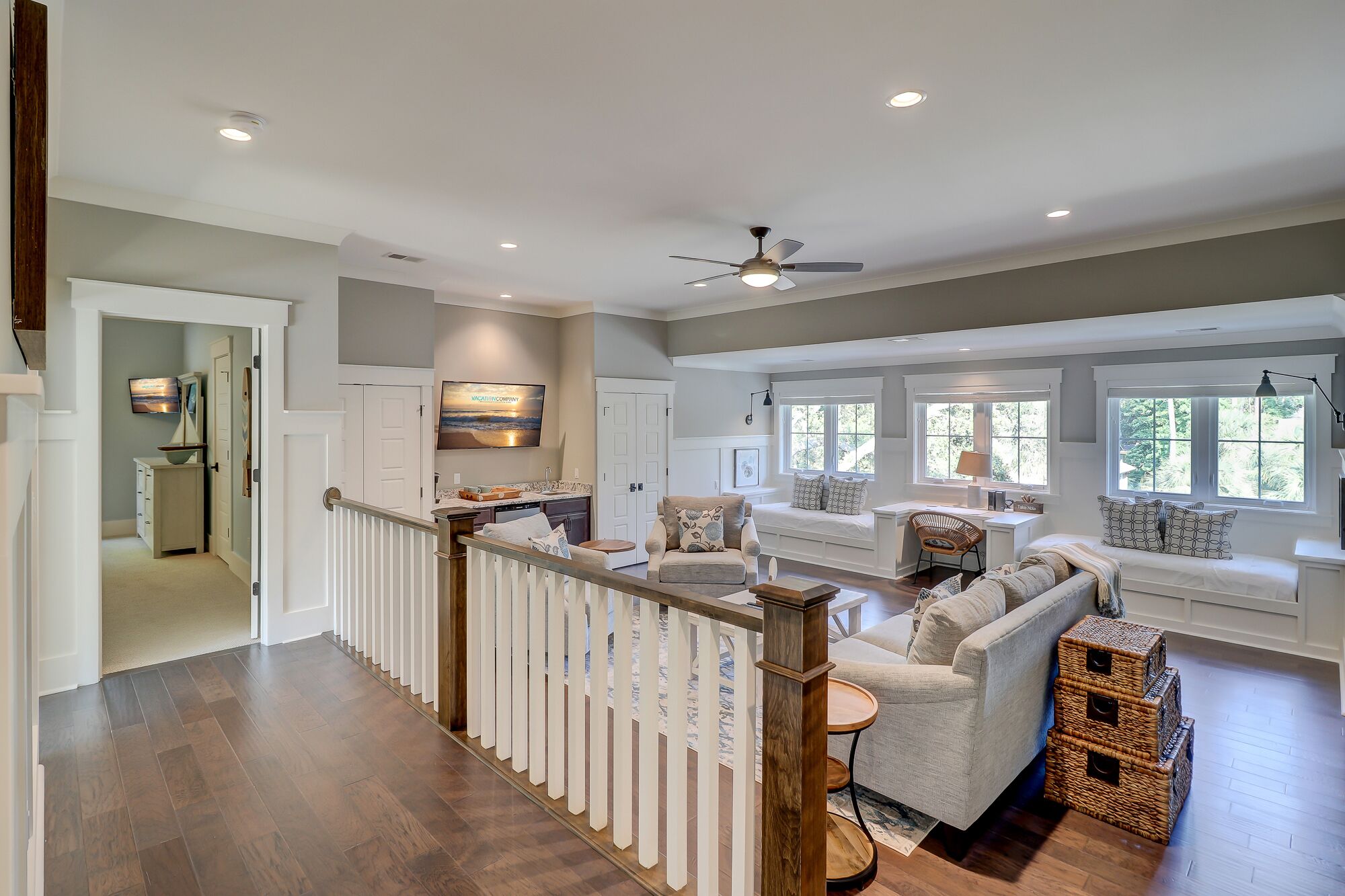A spacious living area with a high ceiling, a built-in bench, and a view of the outdoors through large windows.