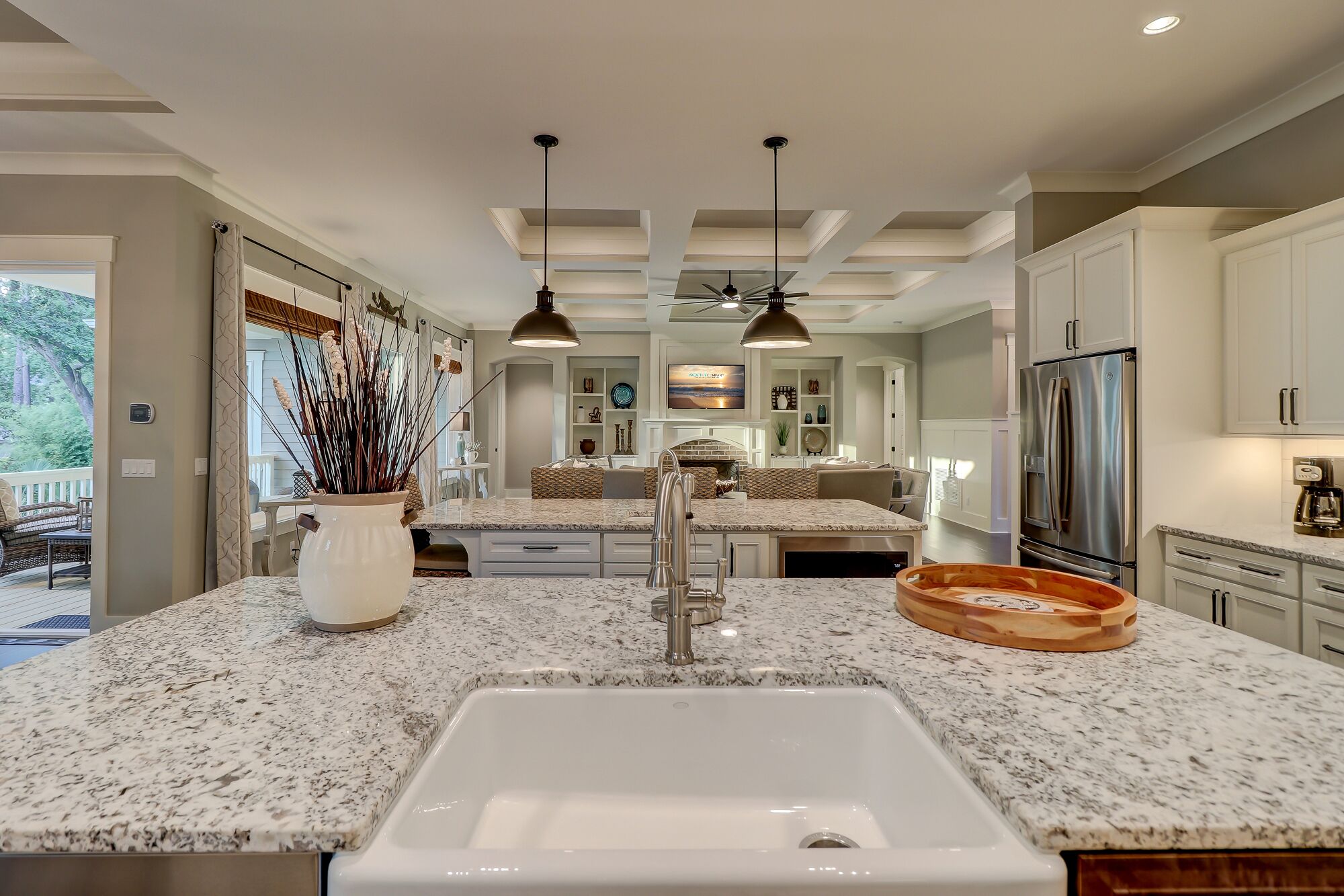 A modern kitchen with granite countertops, a white sink, and stainless steel appliances.