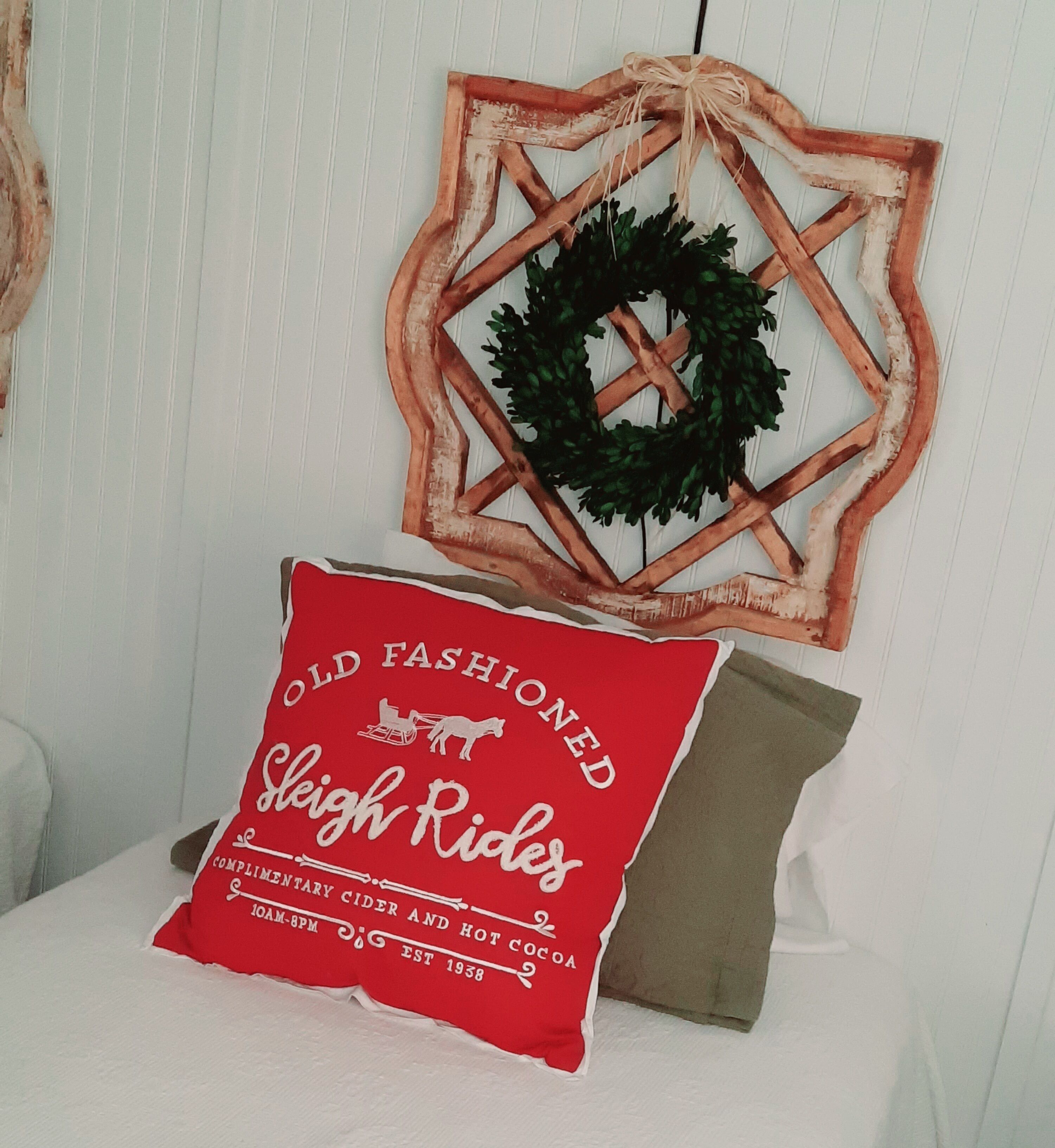 A red pillow with white text and a brown pillow on a white surface.