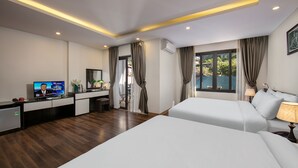 A modern hotel room with two beds, a desk with a TV, and a balcony with curtains. - Sapa Valley View Hotel (Sa Pa)