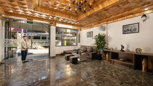A lobby with a marble floor, wooden ceiling, and a sofa set. - Sapa Valley View Hotel (Sa Pa)