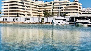 Un hotel frente al agua con varios balcones y un puerto deportivo con yates.