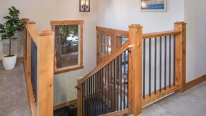 A wooden staircase with a metal railing, a potted plant, and a sign indicating the property's location. - Deck, Bikes, Newer Build in Upper Kings Beach (Kings Beach)