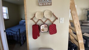 A bedroom with a bed, a wall-mounted sign reading "BEACH Life is Best", and two woven baskets. - Grandpa's cabin nestled in a little woodland village - playground & pond access (Winslow)