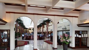 A spacious lobby with high ceilings, a central glass table, and a reception area. - St Pete Beach | Couples Gulf Coast Retreat | Pool + Beach (St. Pete Beach)