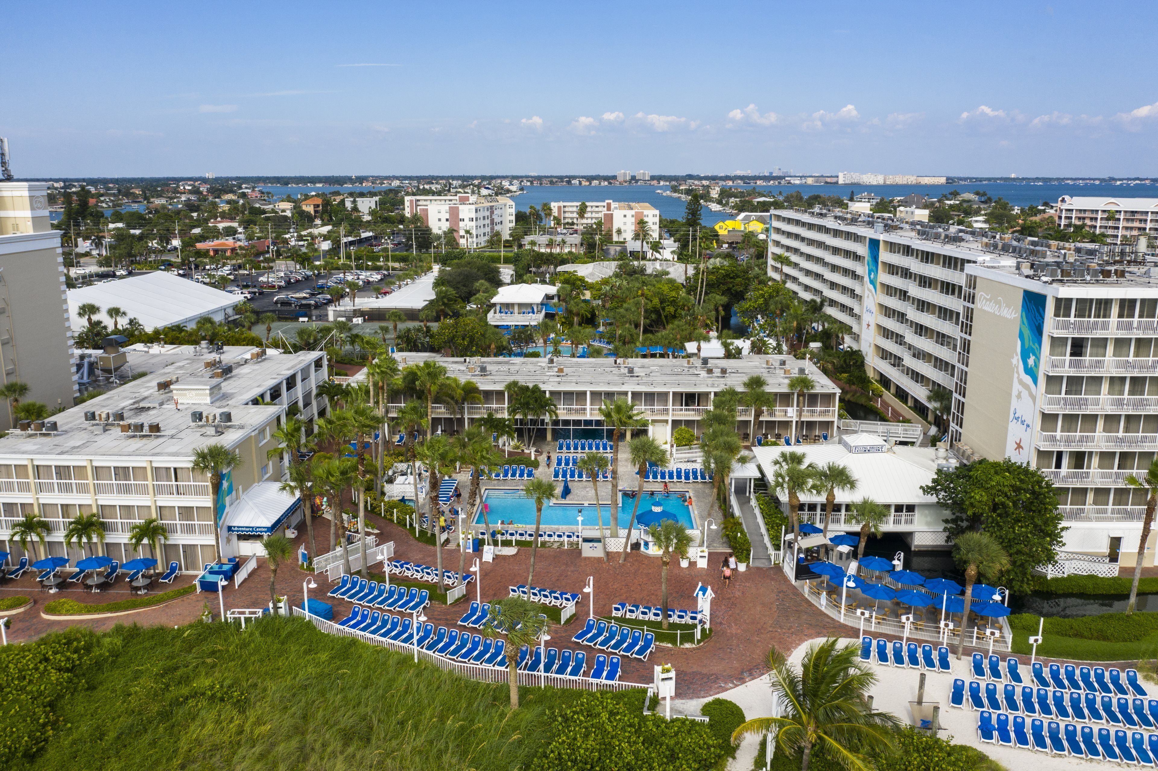 A hotel with multiple floors, a swimming pool, and a view of the sea.