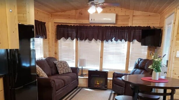 A cozy cabin interior with a kitchen, dining area, and living room. - Christopher Creek Cabins - Cabin 3 (Payson)