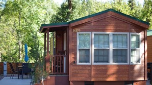 A small wooden cabin with a porch, a covered patio area, and a number '3' sign. - Christopher Creek Cabins - Cabin 3 (Payson)