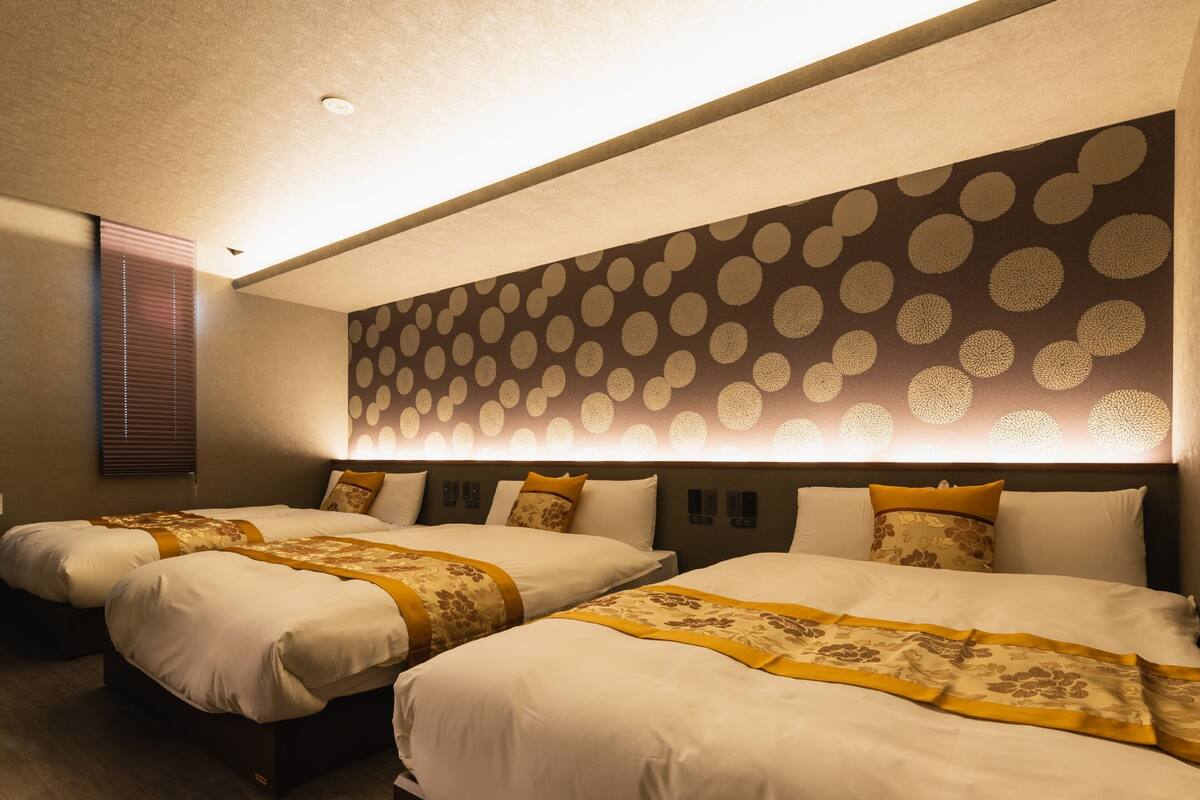 Ein Hotelzimmer mit zwei Betten, einer Wand mit Muster und einer Deckenleuchte.