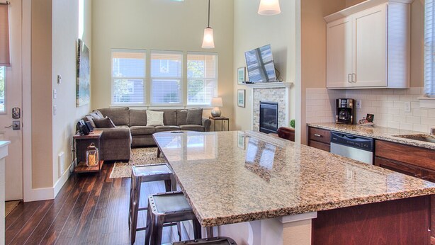 A spacious kitchen with a large island, built-in appliances, and a cozy seating area with a fireplace. - Windswept Cottage - Oyhut Bay Seaside Village (Ocean Shores)