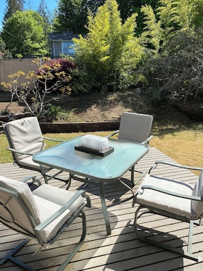 An outdoor patio with a glass-top table and four chairs.
