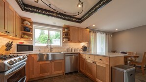 A modern kitchen with wooden cabinets, a stainless steel sink, and a dishwasher. - Country home just minutes from town (Port Angeles)