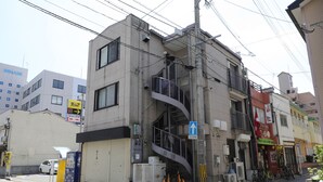 Un edificio de varios pisos con una escalera visible que sube a un nivel superior.