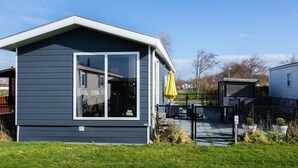 Een modern gelijkvloers huis met een groot raam en een overdekte veranda.
