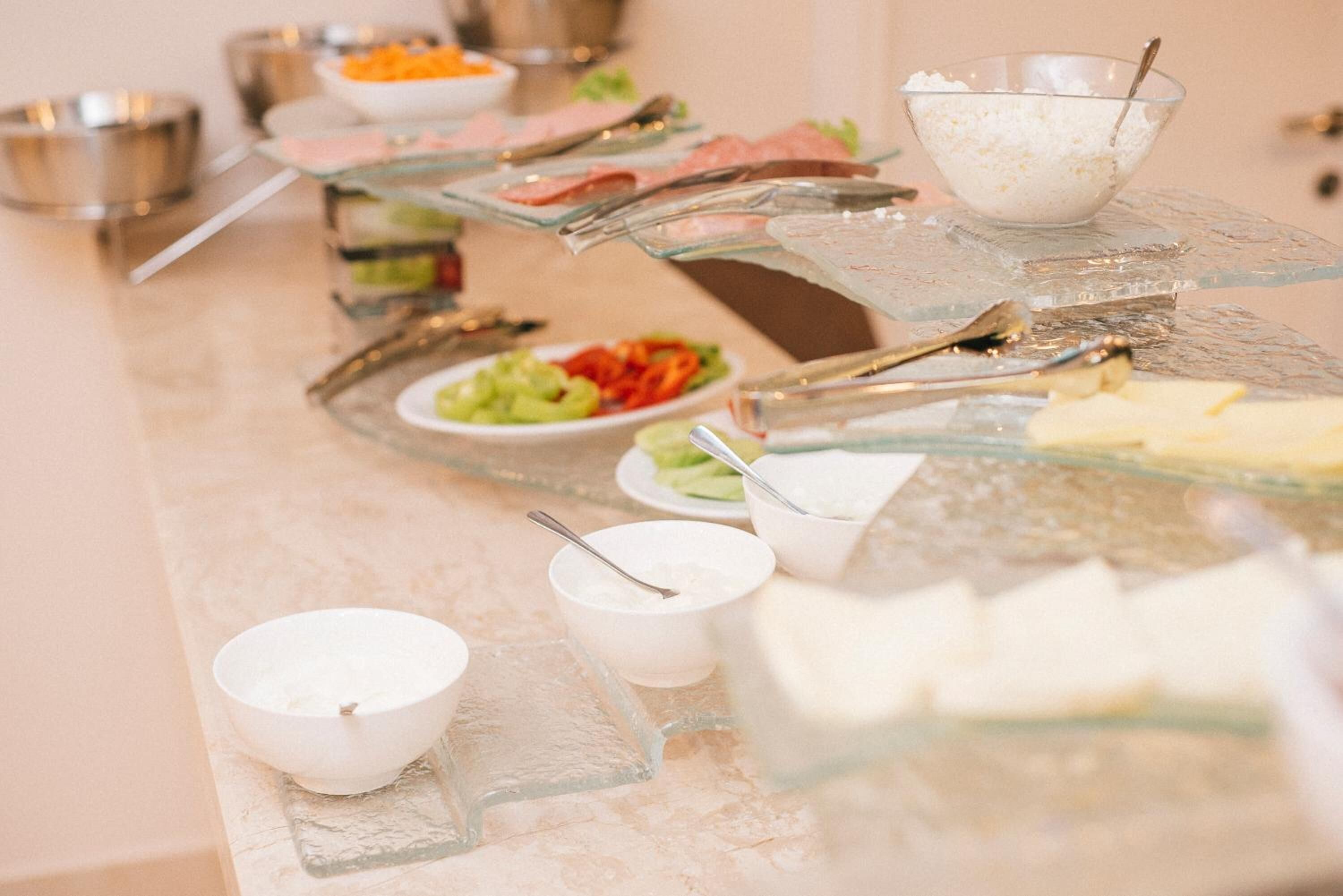A buffet setup with various food items and serving utensils.