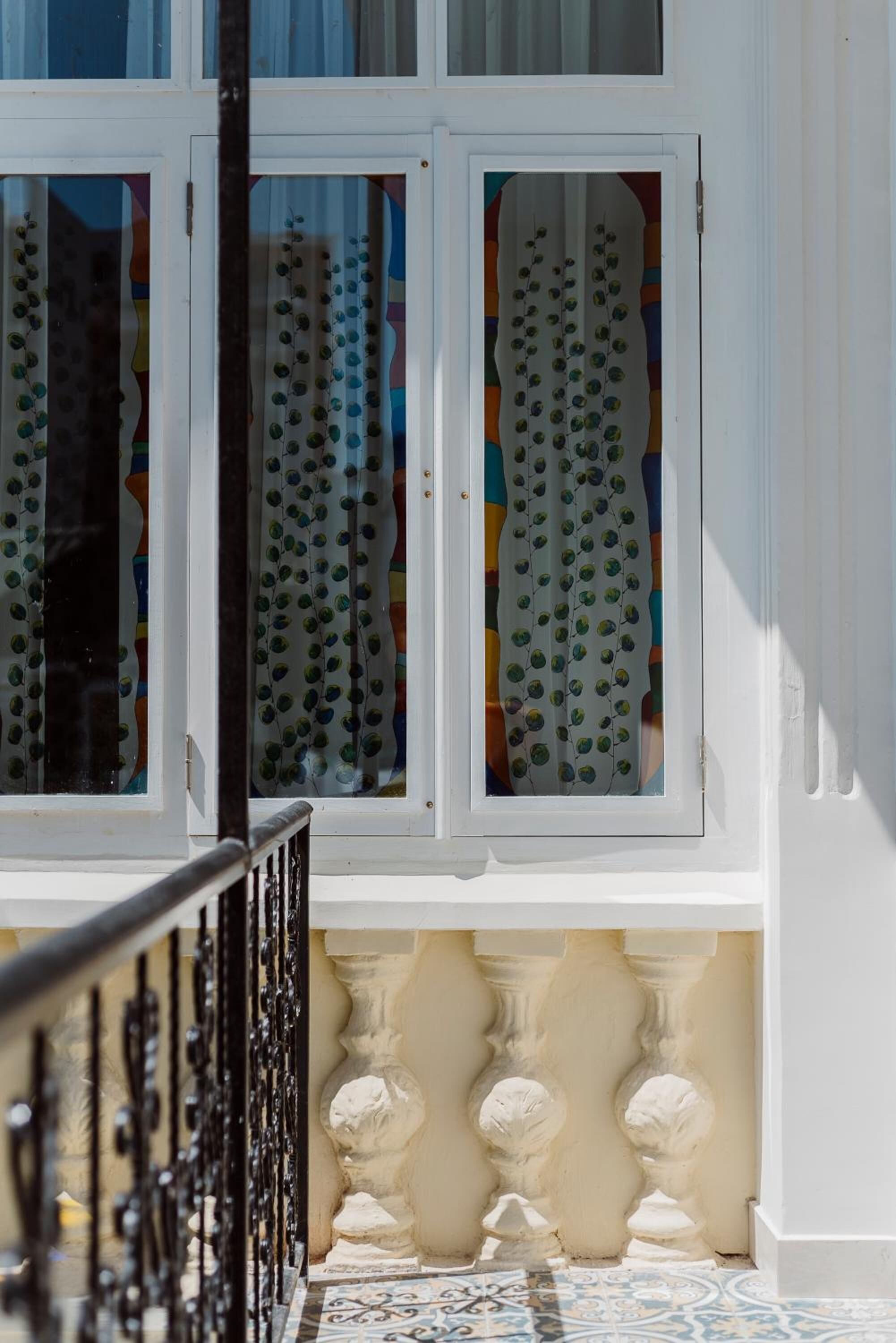 A window with decorative glass and a balustrade.
