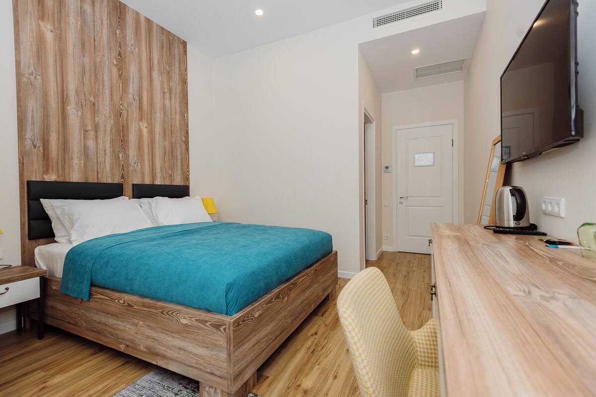 Une chambre à coucher avec un lit en bois, un bureau et une chaise.