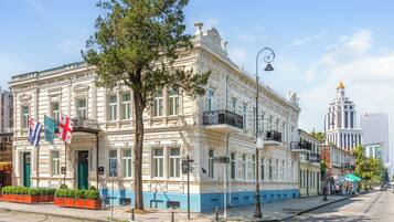 A historic building with a classic architectural style, featuring a prominent entrance and a balcony.