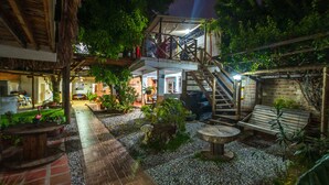 Un patio exterior con una escalera de madera, un área de descanso y una variedad de plantas en macetas.