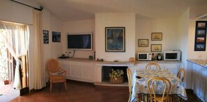 A compact living space with a dining area, kitchenette, and a fireplace.
