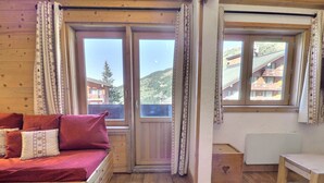 Ein gemütliches Cabin-Zimmer mit einem Bett, einem kleinen Tisch und einem Fenster mit Bergblick.
