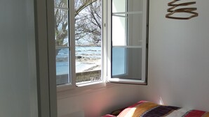 Una habitación con cama, ventana y lámpara colgante.