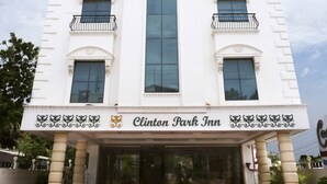 Ein weißes Gebäude mit Balkonen und einem Schild, auf dem „Clinton Park Inn“ steht.