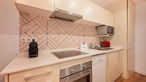 Una cucina compatta con microonde, tostapane e fornello a gas.