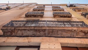 Una terrazza sul tetto con diversi vasi rettangolari e una griglia in metallo.