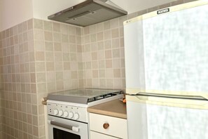 A kitchen with a gas stove, oven, and a white refrigerator. - M035 - Marcelli, three-room apartment with terrace and a / c (Marcelli)