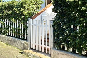 A white gate with a wooden handrail, a white picket fence, and green foliage. - M035 - Marcelli, three-room apartment with terrace and a / c (Marcelli)