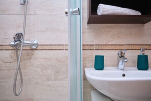Deluxe appartement, 1 slaapkamer, balkon, uitzicht op zee | Badkamer | Een douche, handdoeken, zeep, shampoo