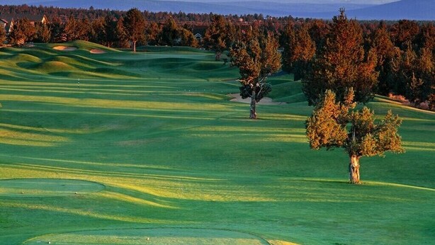 Un parcours de golf avec une montagne en arrière-plan.