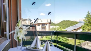 A table set with white napkins, a glass of water, and a vase of white flowers. - Chesa Corvatsch 111 - Champfer by Interhome (Champfer)