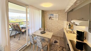 Una cocina compacta con zona de comedor, vistas al exterior y una pared de ladrillo.